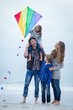 © WavebreakmediaMicro - Cheerful family with kite at sea shore
