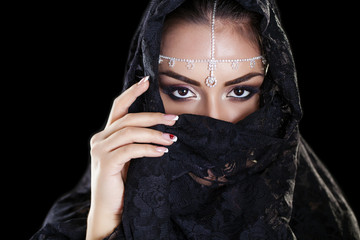 Beautiful Woman in Middle Eastern Niqab veil on isolated black b