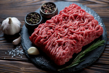 Wall Mural - Close-up of raw fresh ground beef meat on a stone slate plate