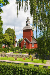 Wall Mural - Cemetery with a red Wooden Church