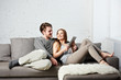 Romantic relaxed young couple using tablet computer on sofa