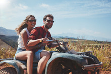 Happy Young Couple Driving A Quad Bike