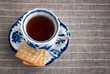 Black tea served in porcelain Gzhel cup with crackers on saucer, top view