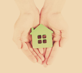 Sticker - Female hands with model of house on light background