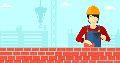 Wall Mural - Bricklayer with spatula and brick.