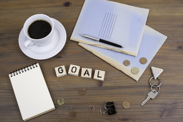 Wall Mural - Coffe, pen, money and blocknot on a desk and word Goal