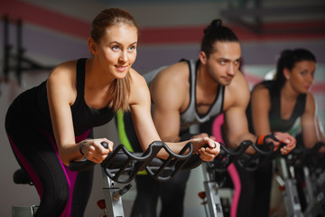 Group of fit people cycling in fitness club