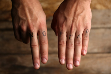 Tattoo inscriptions on male fingers drawn with marker