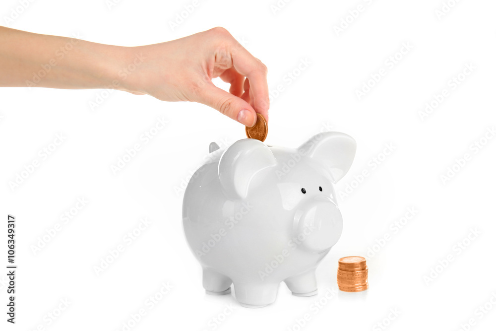 Hand putting coin into piggy bank, isolated on white