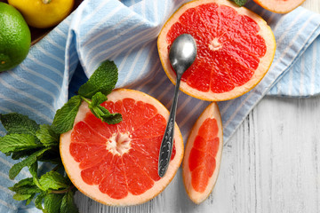 Wall Mural - Pieces of grapefruit with spoon on wooden light background