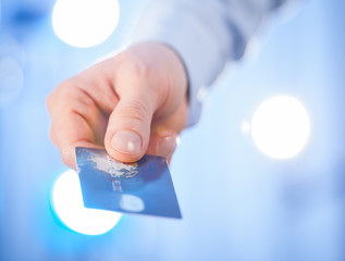 Businessman's hand giving credit card to you