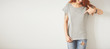 © WHstudio Leushin N - Young girl wearing grey blank t-shirt and blue jeans. Concrete wall background with copy space for your text message or promotional content