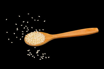 Wall Mural - Sesame Seeds in Wooden Spoon on Black Background