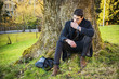 © theartofphoto - Handsome young man leaning against tree