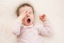 Sleeping Beautiful And Yawning Baby Toddler On The Bed. Portrait