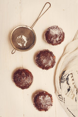 Wall Mural - Top view on fresh baked chocolate muffins on the table