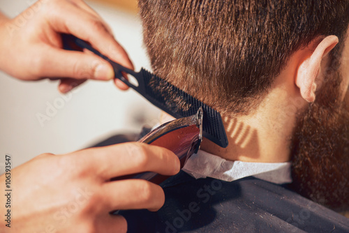 Fotografie, Obraz Professional barber cutting hair of his client