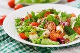 Fototapeta  - Dietary salad with tomatoes, mozzarella lettuce with honey-mustard dressing