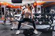 © golubovy - Professional  bodybuilding athlete relax after exhausting training.  Athlete relax and drink  water from sport bottle in gym interior.