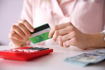 Poster - Female calculate with credit card and money, closeup