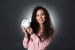 © Africa Studio - Beautiful young girl holding piggy bank on grey background