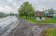 Landscape with draw-well as a small wooden house at roadside in Lyubka village, Sumskaya oblast, Ukraine