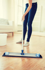 Wall Mural - close up of woman with mop cleaning floor at home