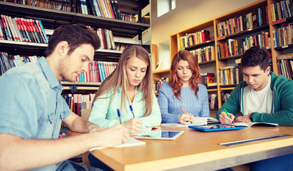 Poster - happy students writing to notebooks in library