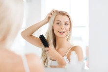 Happy Woman Brushing Hair With Comb At Bathroom