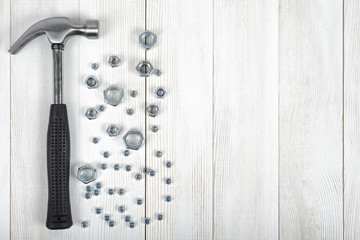 Wall Mural - Top view of construction tools including nuts and hammer on wooden DIY workbench with open space.