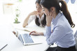 © Monet - Two business women have to work while looking at a laptop together