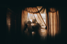 Silhouette Of A Bride And Groom On The Background Of A Window Wi