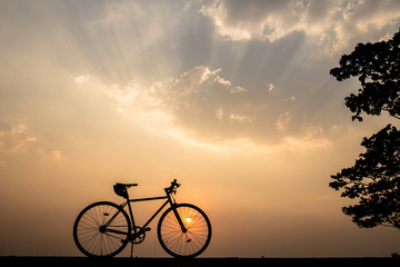 Wall Mural - Silhouette of a bike on sky background on sunset