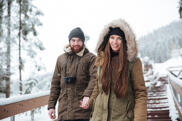 Poster - Couple holding hands and walking down the stairs in winter