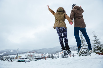 Poster - Couple jumping and having fun together in winter