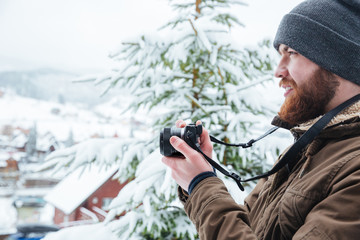 Poster - Focused man using camera and taking photos in winter