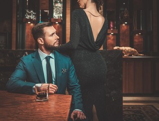 Well-dressed couple in luxury apartment interior.