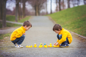 Sticker - Two adorable children, boy brothers, playing in park with rubber