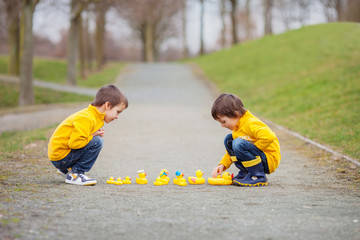 Sticker - Two adorable children, boy brothers, playing in park with rubber