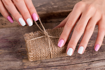 Fotomurales - Women's hands with a nice manicure unleash a gift.