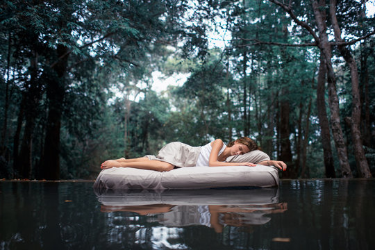 Fototapete - A hidden place. Sleeping woman in deep forest lies on airbed
