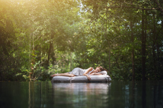 Fototapete - A hidden place. Sleeping woman in deep forest lies on airbed