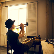 Caucasian Man Playing Trumpet In Kitchen