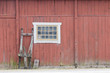 Traditional old red barn wall, a window and a sled