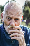 starszy mężczyzna palący papierosa