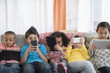 © JGI/Jamie Grill/Blend Images - Children using technology on sofa