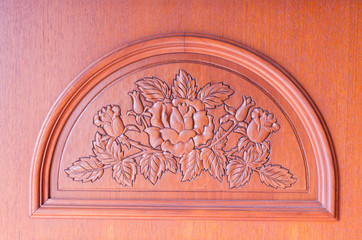 pattern of flower carved on brown wood background