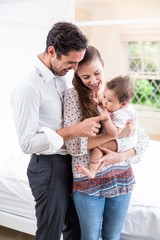 Wall Mural - Smiling parents playing with baby