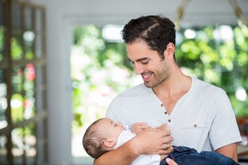 Wall Mural - Smiling father carrying baby 