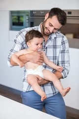 Wall Mural - Father smiling while carrying son